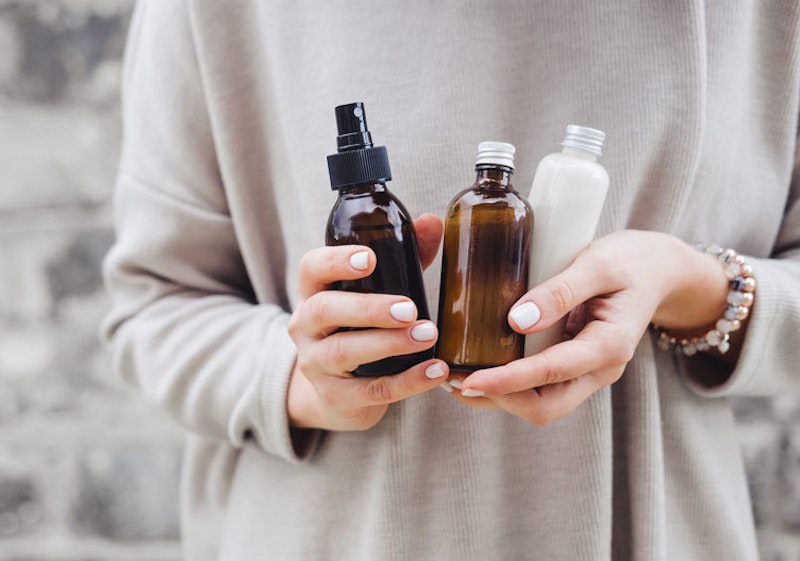 Hands holding three bottles of essential oils products